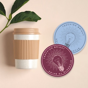 May include: Two round stickers with a lightbulb graphic and text that reads "Teaching Bright Students to Shine" and "Teaching Bright Students to Shine". One sticker is blue and the other is maroon.
