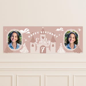 May include: A personalized birthday banner in a soft pink hue, featuring a castle design and the name "Emily" with the number "7." The banner includes two circular photo frames with a girl's image, princess silhouettes, and decorative elements.