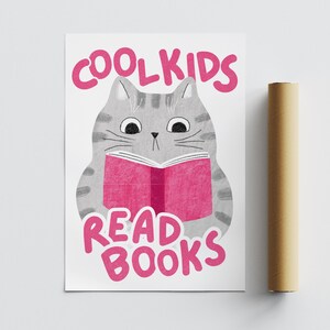 May include: A gray cat with pink ears and a pink nose is reading a pink book. The text on the poster reads "Cool Kids Read Books".