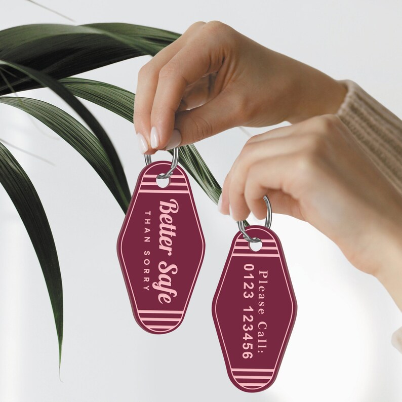 May include: Two red motel keychains with white and pink text. One keychain says "Better Safe Than Sorry" and the other says "Please Call: 0123 123456".