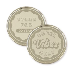 K&ouml;nnte beinhalten: Zwei runde silberfarbene M&uuml;nzen mit wei&szlig;em Hintergrund. Die erste M&uuml;nze sagt "SOBER FOR 00 YEARS" und die zweite M&uuml;nze sagt "SOBER Vibes ONLY".