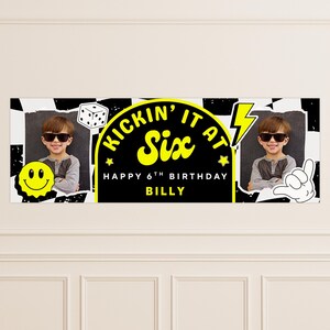 May include: A black and white banner with the text "KICKIN' IT AT Six" in yellow, celebrating a 6th birthday. Includes a photo of a child wearing sunglasses, a smiley face, a die, and a hand gesture.