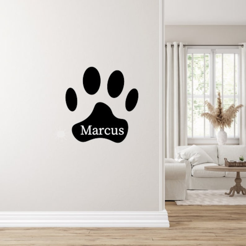 May include: Black paw print wall decal with the name "Marcus" written inside.