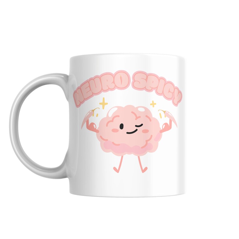 Puede incluir: Taza de cer&aacute;mica blanca con un personaje de dibujos animados de cerebro rosa flexionando sus m&uacute;sculos y el texto "Neuro Spicy" en letras rosas.
