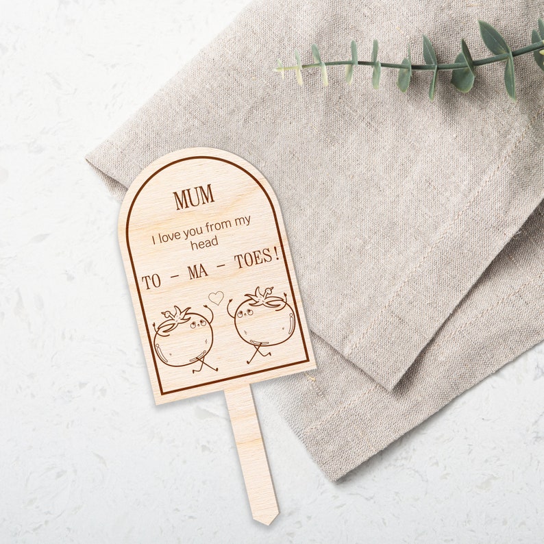 May include: Wooden sign with a heart and two cartoon tomatoes. The sign reads "MUM I love you from my head TO - MA - TOES!"