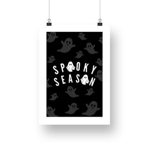 Puede incluir: Un p&oacute;ster negro con borde blanco que presenta un patr&oacute;n de ilustraciones de fantasmas grises. Las palabras "Spooky Season" est&aacute;n escritas en blanco, con la letra "O" en "Spooky" y la letra "A" en "Season" reemplazadas por ilustraciones de fantasmas.