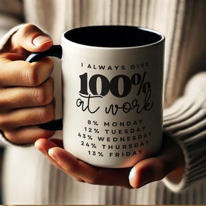 May include: White ceramic coffee mug with a black handle and black rim. The mug has black text that reads "I ALWAYS GIVE 100% at work" and a list of percentages for each day of the week: 8% Monday, 12% Tuesday, 43% Wednesday, 24% Thursday, 13% Friday.