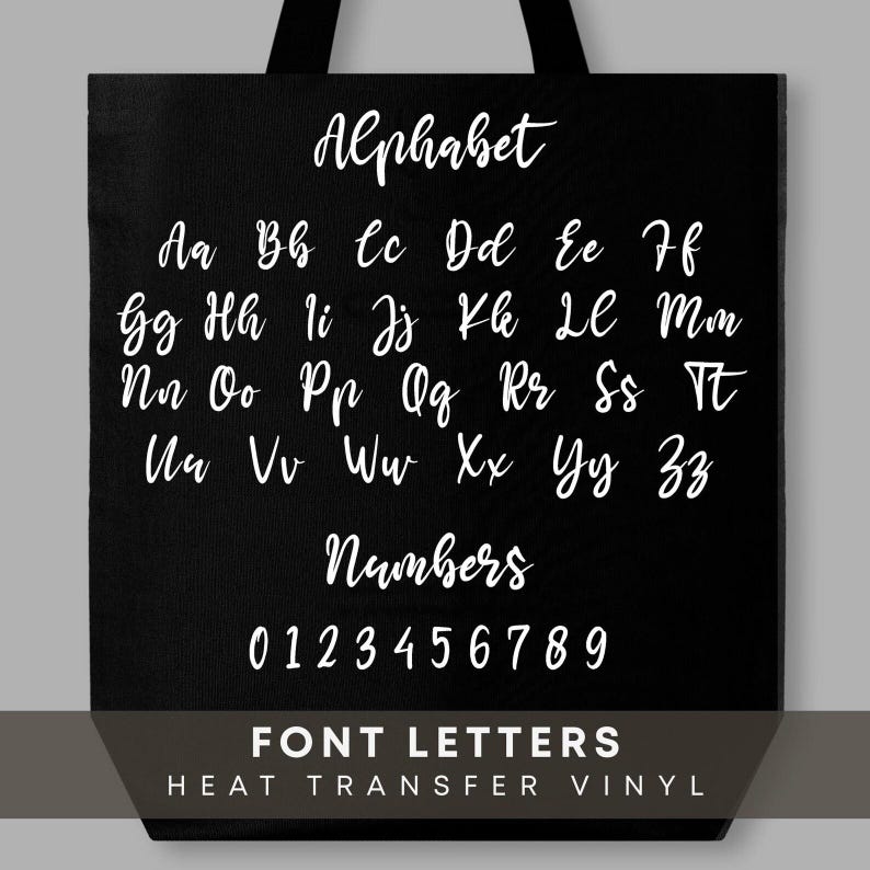 May include: Black tote bag featuring the alphabet and numbers in a white, cursive font. The bag also includes the text "FONT LETTERS HEAT TRANSFER VINYL" in white. The design is simple and clean.
