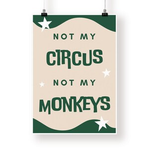 May include: A beige poster with green and white accents. The poster features the text "Not my circus, not my monkeys" in a bold, green font. The poster is decorated with white stars.