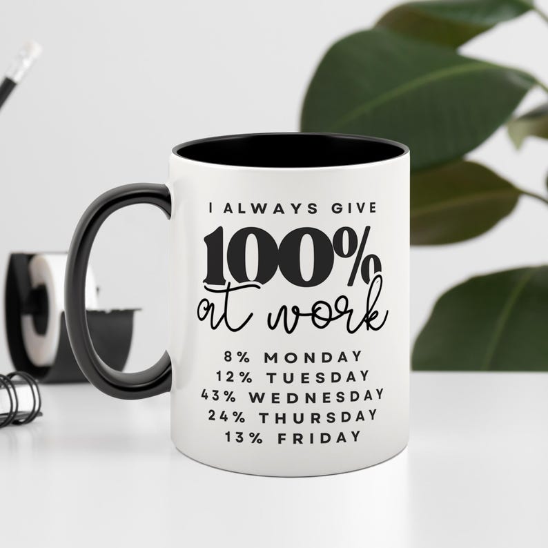May include: White ceramic coffee mug with a black interior and handle. The mug has black text that reads "I ALWAYS GIVE 100% at work" and a list of percentages for each day of the week: 8% Monday, 12% Tuesday, 43% Wednesday, 24% Thursday, 13% Friday.