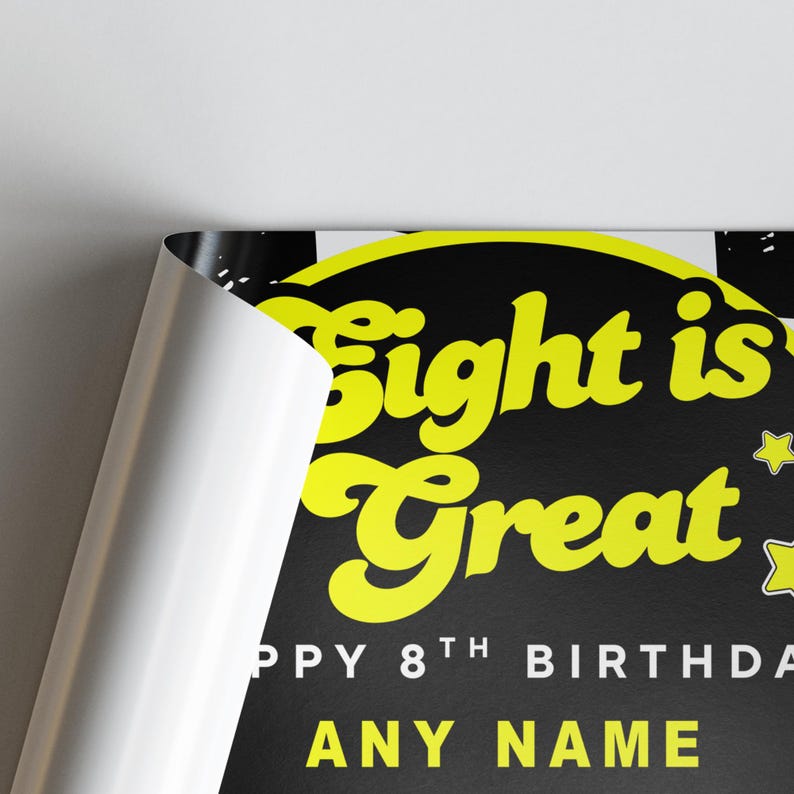 May include: A black and yellow birthday poster with the text "Eight is Great" and "Happy 8th Birthday". The poster has a retro design with stars and space for a name. The poster is partially rolled.