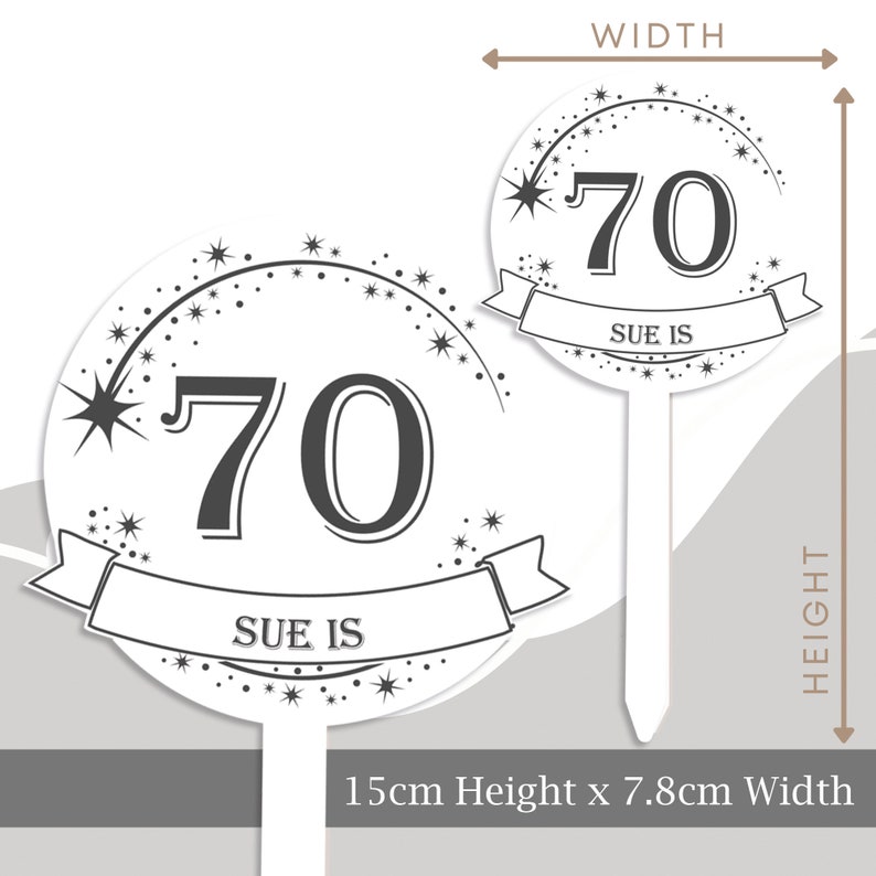 May include: White cake topper with a black and white design. It features the number 70 with a banner that says "Sue is" and a shooting star with a trail of stars. The topper is 7.8 cm wide and 15 cm high.