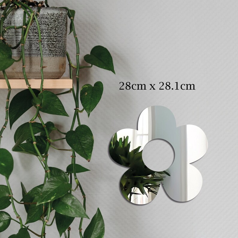 May include: A silver flower-shaped mirror with a hole in the center. The mirror is 28 inches by 28.1 inches.