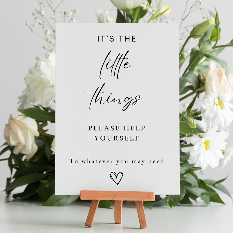 May include: White sign with black text that reads "It's the little things. Please help yourself to whatever you may need." with a small heart drawn at the bottom.