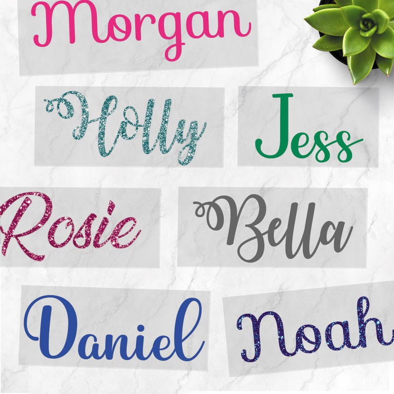 May include: A selection of name decals in different colours and fonts. Names include "Morgan," "Holly," "Jess," "Rosie," "Bella," "Daniel," and "Noah." The decals are presented on a white background.