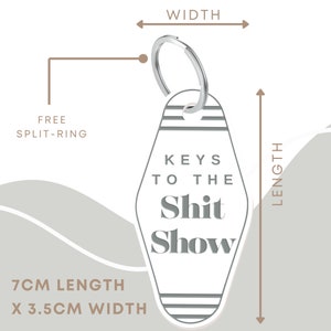 May include: White motel key chain with black text that reads "Keys to the Shit Show". The keychain is 7 cm long and 3.5 cm wide and includes a free split ring.