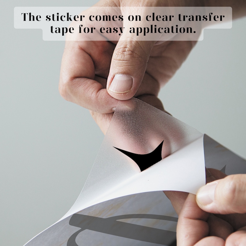 Puede incluir: Una mano retirando una cinta de transferencia transparente de una pegatina. La pegatina viene con una cinta de transferencia transparente para una f&aacute;cil aplicaci&oacute;n.