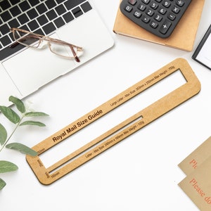 May include: A wooden Royal Mail size guide with two cutouts for measuring the dimensions of letters and large letters. The guide is labeled with the maximum size and weight for each type of letter.