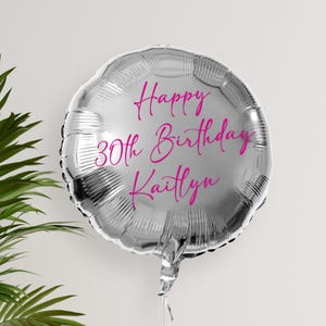 May include: Silver balloon with the text "Happy 30th Birthday Kaitlyn" in pink lettering.