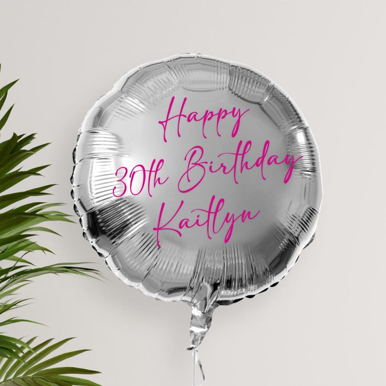 May include: Silver balloon with the text "Happy 30th Birthday Kaitlyn" in pink lettering.