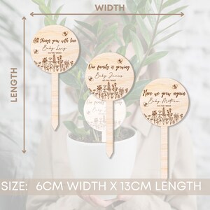 K&ouml;nnte beinhalten: Drei h&ouml;lzerne Pflanzenmarkierungen mit floralem Design und Bienen-Akzenten. Die Markierungen sind 6 cm breit und 13 cm lang. Der Text auf den Markierungen lautet: "All things grow with love Baby Ley 18/06/2005", "Our family is growing Baby James 27/04/2005" und "Neve we grow again Baby Mathew 01/05/2005".
