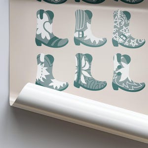May include: A pattern of nine teal blue cowboy boots with white floral designs. The boots are arranged in three rows of three.