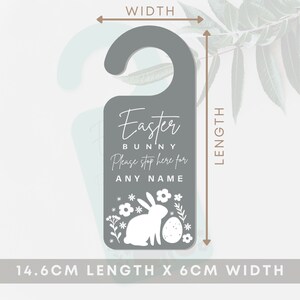 May include: Gray door hanger with a white bunny and Easter egg design. The text reads "Easter Bunny Please stop here for ANY NAME". The hanger measures 14.6 cm in length and 6 cm in width.