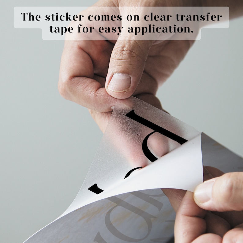 May include: A hand is peeling back a clear transfer tape from a black vinyl sticker. The sticker comes on clear transfer tape for easy application.