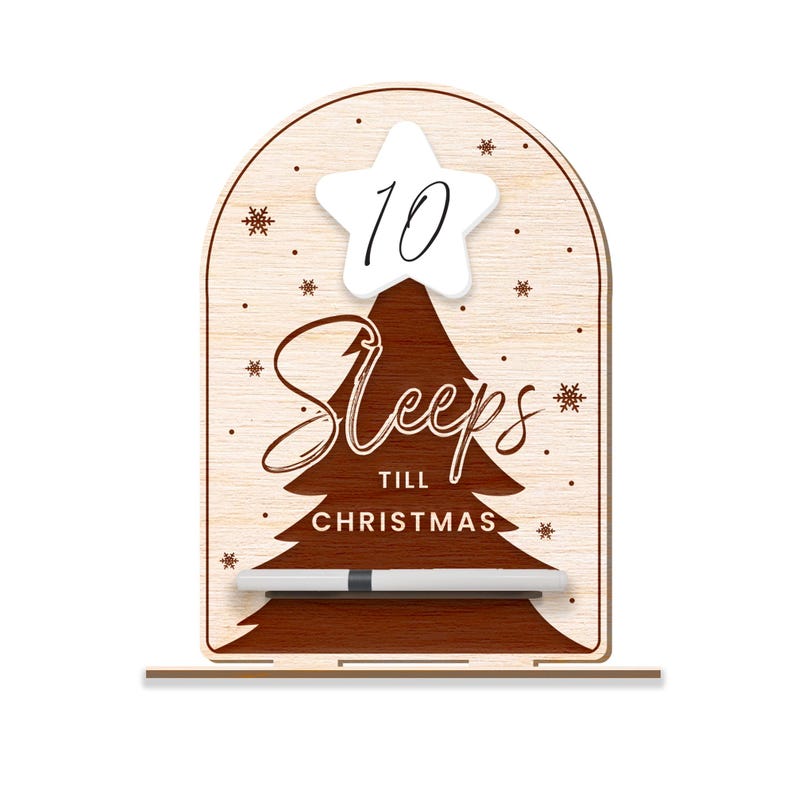 Puede incluir: Un letrero de cuenta atr&aacute;s de Navidad de madera con un dise&ntilde;o de &aacute;rbol marr&oacute;n y el texto "Sleeps till Christmas". Una estrella blanca con el n&uacute;mero 10 est&aacute; en la parte superior del &aacute;rbol. Se incluye un marcador blanco.