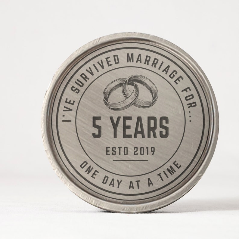 Puede incluir: Un recuerdo redondo de metal plateado con el texto "I've Survived Marriage For... 5 Years Estd 2019 One Day at a Time." Dos anillos entrelazados est&aacute;n en el centro. Los bordes tienen una apariencia texturizada.