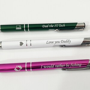 May include: Three personalized pens with different colored bodies and engravings. The top pen is green with a laptop icon and the text "Dad the IT Tech". The middle pen is white with a heart icon and the text "Love you Daddy". The bottom pen is pink with a fish icon and the text "I would rather be fishing".