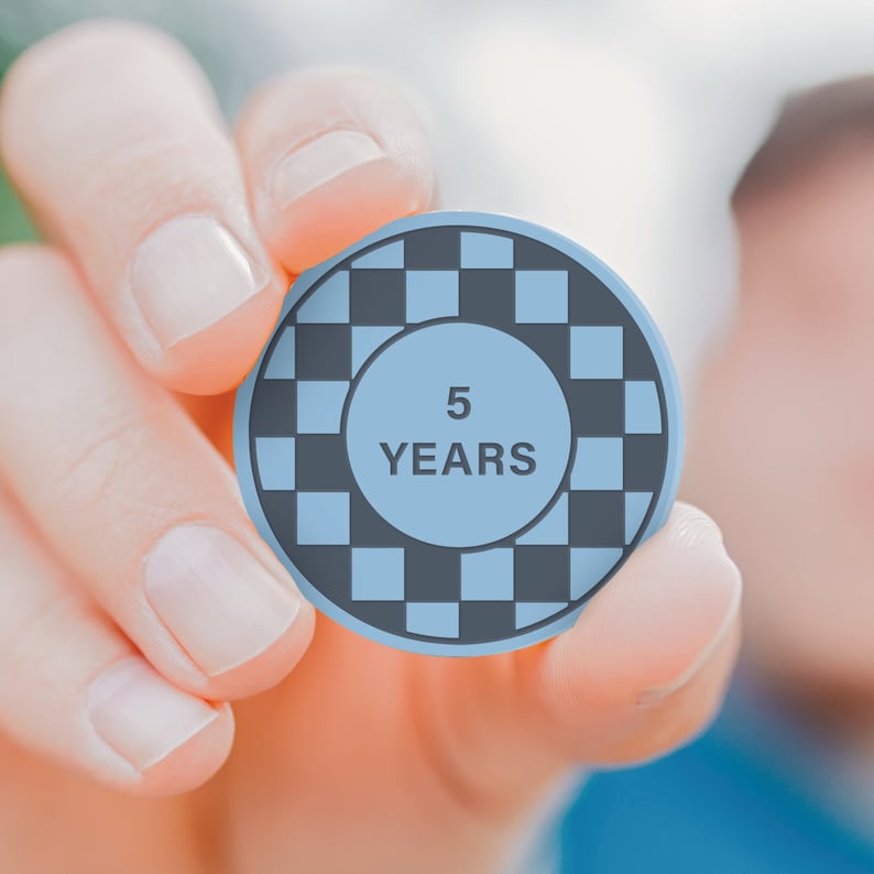 May include: A blue and black checkerboard pattern circle with the text "5 YEARS" in the centre.
