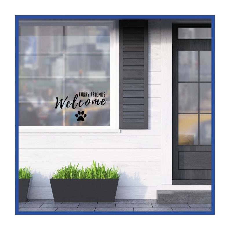 May include: A white house with a black door and a window with a sign that says "Furry Friends Welcome" with a paw print. There are two potted plants in front of the house.