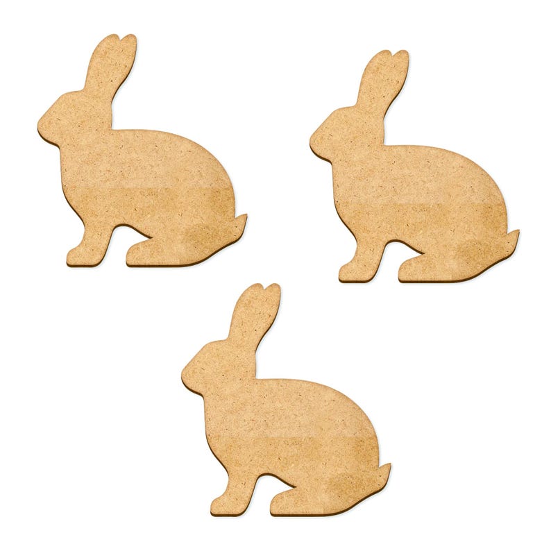 May include: Three brown cardboard bunny shapes cut out on a white background.