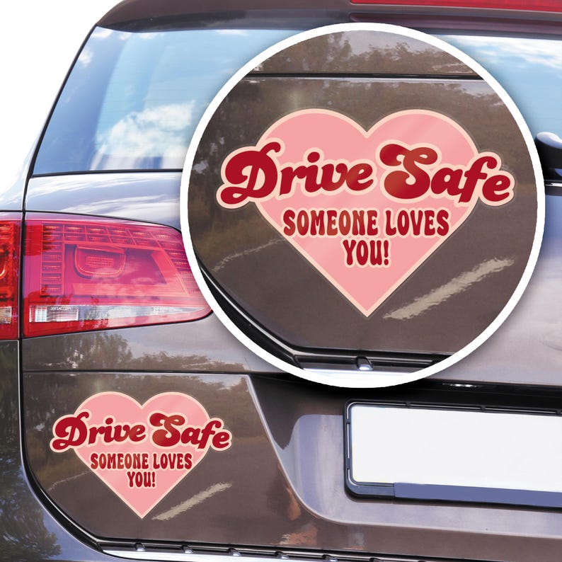 May include: A car with a heart-shaped sticker that says "Drive Safe SOMEONE LOVES YOU!" in red and pink. The sticker is on the car's trunk, with a matching sticker below. The car is brown.