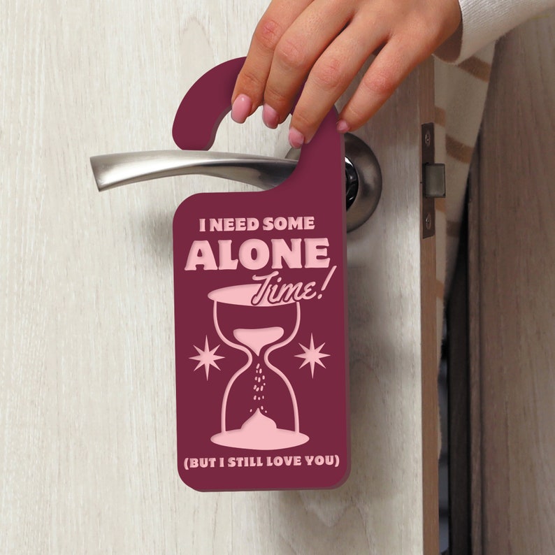 May include: A burgundy door hanger with a pink hourglass and the text "I need some alone time! (But I still love you)".