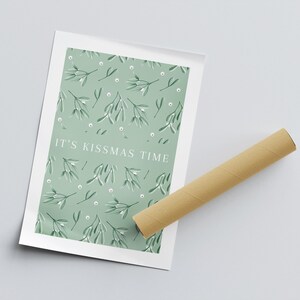 Puede incluir: Una impresi&oacute;n de arte imprimible verde y blanca con un patr&oacute;n de mu&eacute;rdago y el texto "It's Kissmas Time".