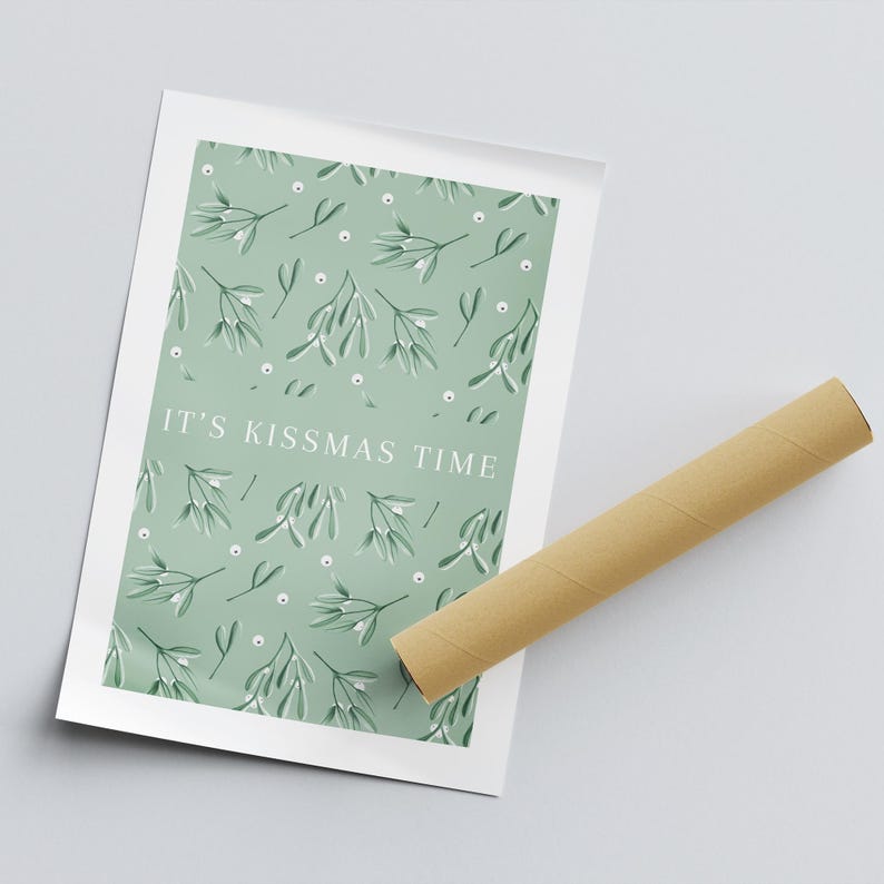 Puede incluir: Una impresi&oacute;n de arte imprimible verde y blanca con un patr&oacute;n de mu&eacute;rdago y el texto "It's Kissmas Time".