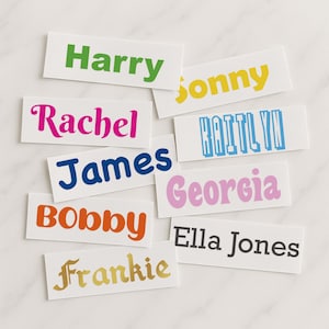 Puede incluir: Una colecci&oacute;n de etiquetas de nombres coloridas con nombres como Harry, Sonny, Rachel, James, Bobby, Frankie, Kaitlyn, Georgia y Ella Jones.