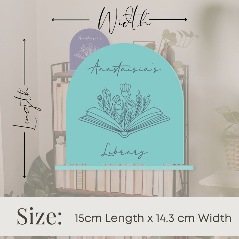 May include: A turquoise blue bookend shaped like an open book with flowers growing out of it. The bookend is 15 cm long and 14.3 cm wide. The text "Anastasia's Library" is written on the bookend.