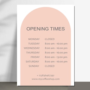 May include: A rectangular sign with a peach-colored arch and text. The sign reads "OPENING TIMES" in gray. Below, the days of the week and opening hours are listed. The sign also includes a phone number and website address.