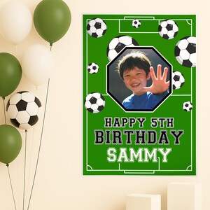May include: A green soccer-themed birthday banner with the text "HAPPY 5TH BIRTHDAY SAMMY." The banner features a photo of a smiling child, soccer balls, and a soccer field design. Balloons in white and green are in the background.