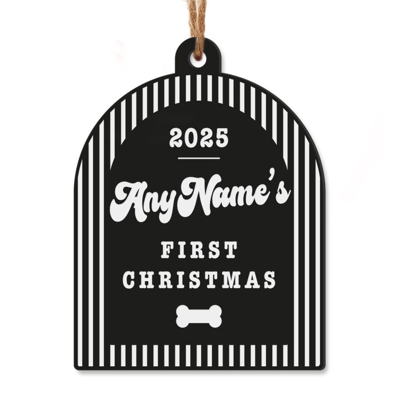 May include: Black and white dog bone-shaped Christmas ornament with the text "2025 Any Name's First Christmas" and a dog bone graphic. The ornament has a striped border and a jute string for hanging.