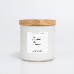 May include: A white candle with a wooden lid. The label says "Chocolate + Orange". The candle is 283g and has a burn time of 10 hours. The candle is hand poured.