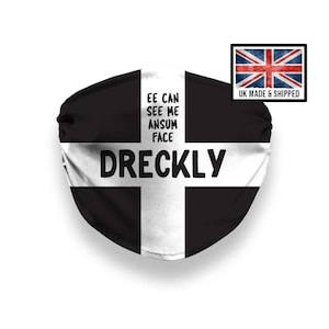 Puede incluir: Una mascarilla facial en blanco y negro con el texto "EE CAN SEE ME ANSUM FACE DRECKLY". La mascarilla tiene un diseño de cruz blanca y una pequeña bandera de la Union Jack en la esquina.