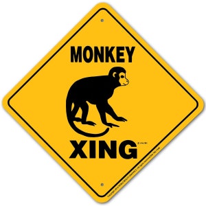 May include: Yellow diamond-shaped warning sign with black text and a black silhouette of a monkey. The sign reads "MONKEY XING".