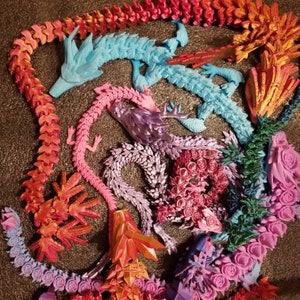 May include: A collection of colorful dragon figurines made of plastic. The dragons are in various poses and have intricate details. The dragons are arranged in a circular pattern on a dark background.