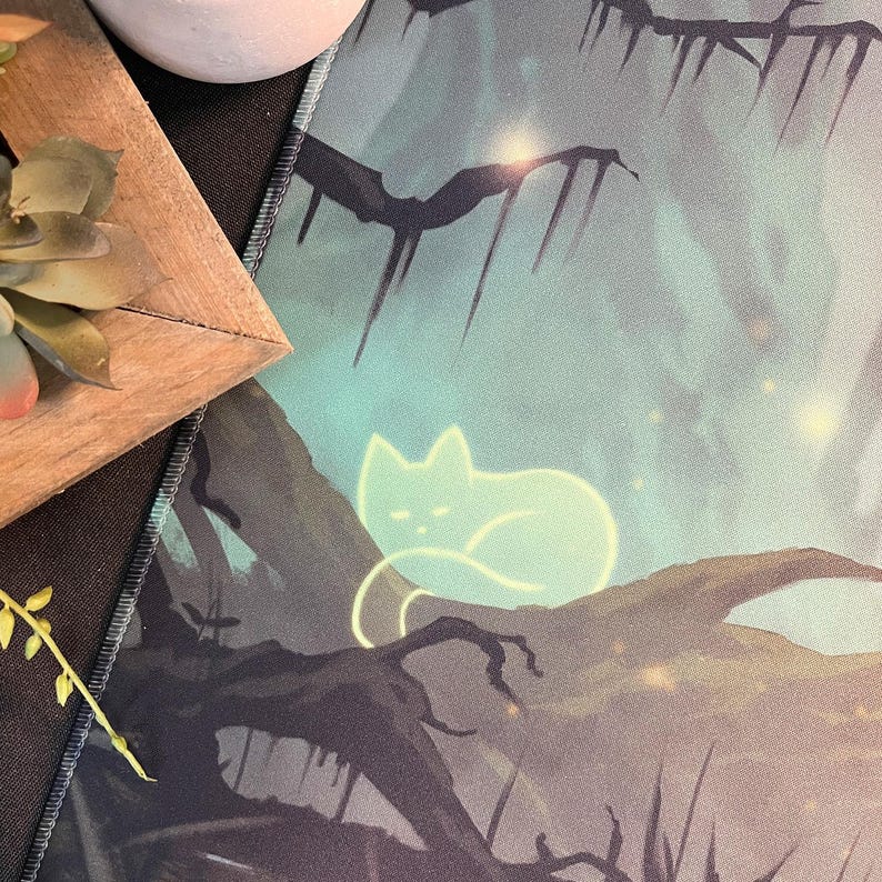 May include: A green and blue mousepad with a glowing white cat sitting on a branch. The background is a dark forest with glowing lights.