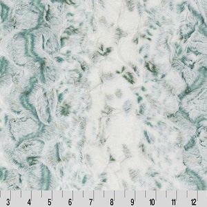 May include: White and teal faux fur fabric with a swirling pattern.