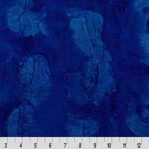 May include: A close-up of a blue fabric with a fuzzy texture. The fabric has a swirling pattern.